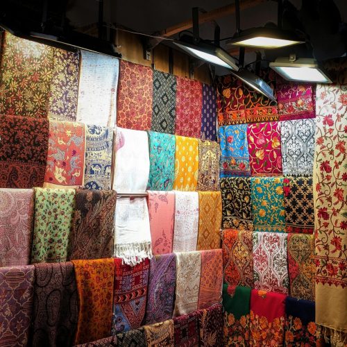 Vibrant Indian fabrics displayed in a market, showcasing colorful traditional patterns and textiles.